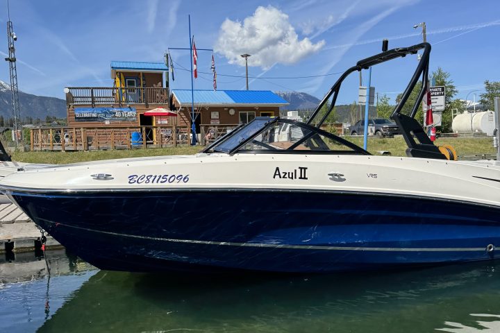 A boat named 'Ami II' docked on a sunny day.